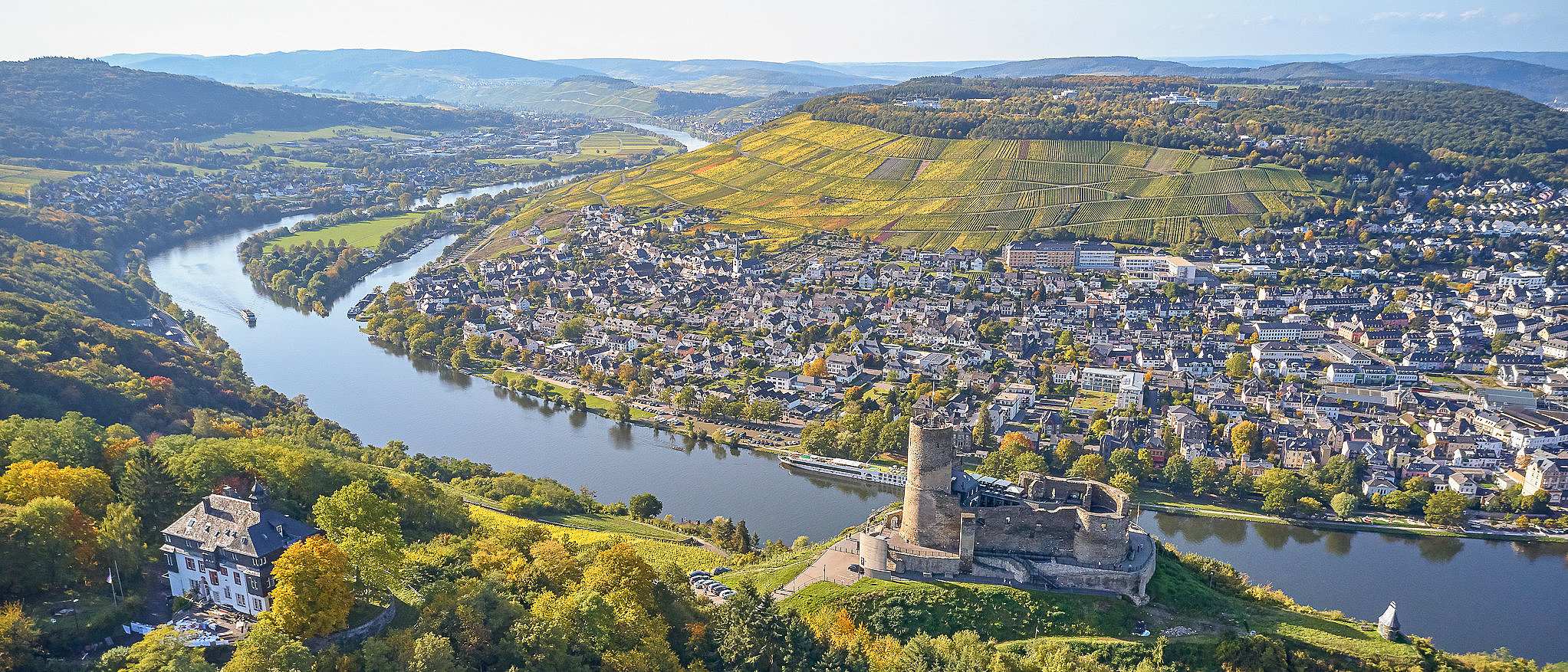 Bild aus der Vogelperspektive auf die Burg Landshut und das Moseltal Drohnenbild der Burg Landshut, die auf einem Berg hoch über der Mosel thront. Im Hintergrund die Mosel und der Stadtteil Kues.