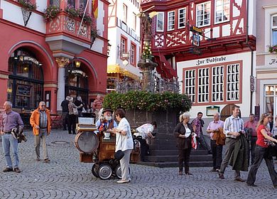 Urlaub an der Mosel: Die Moselregion kennenlernen und Bernkastel-Kues besichtigen. Zu sehen ist ein Spielmann auf dem historischen Marktplatz. 